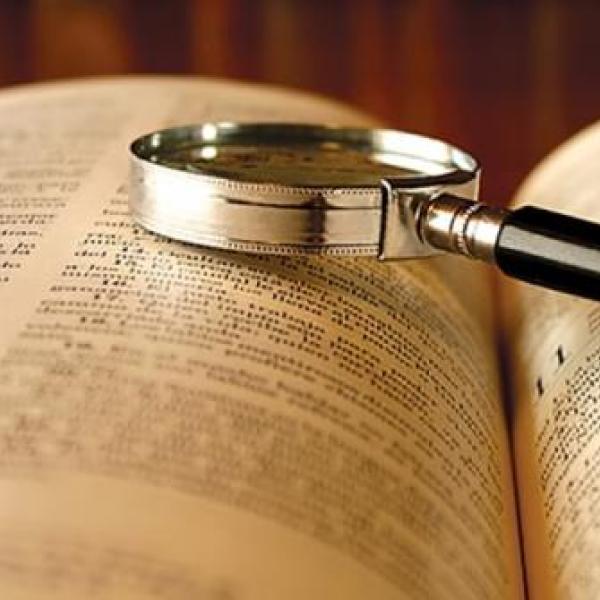 Open book with a magnifying glass on it
