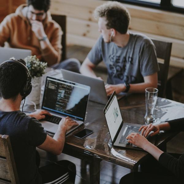 People sitting at a desk working at computers