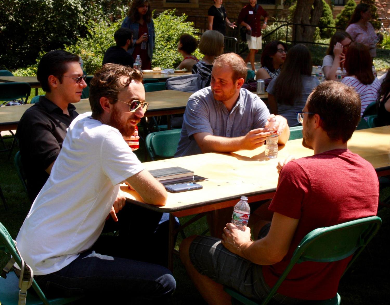 4 male students chatting at a table.