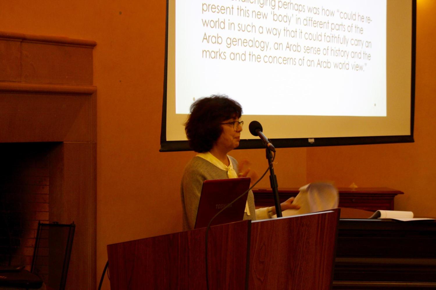 Yusur al Madani standing at a lectern 