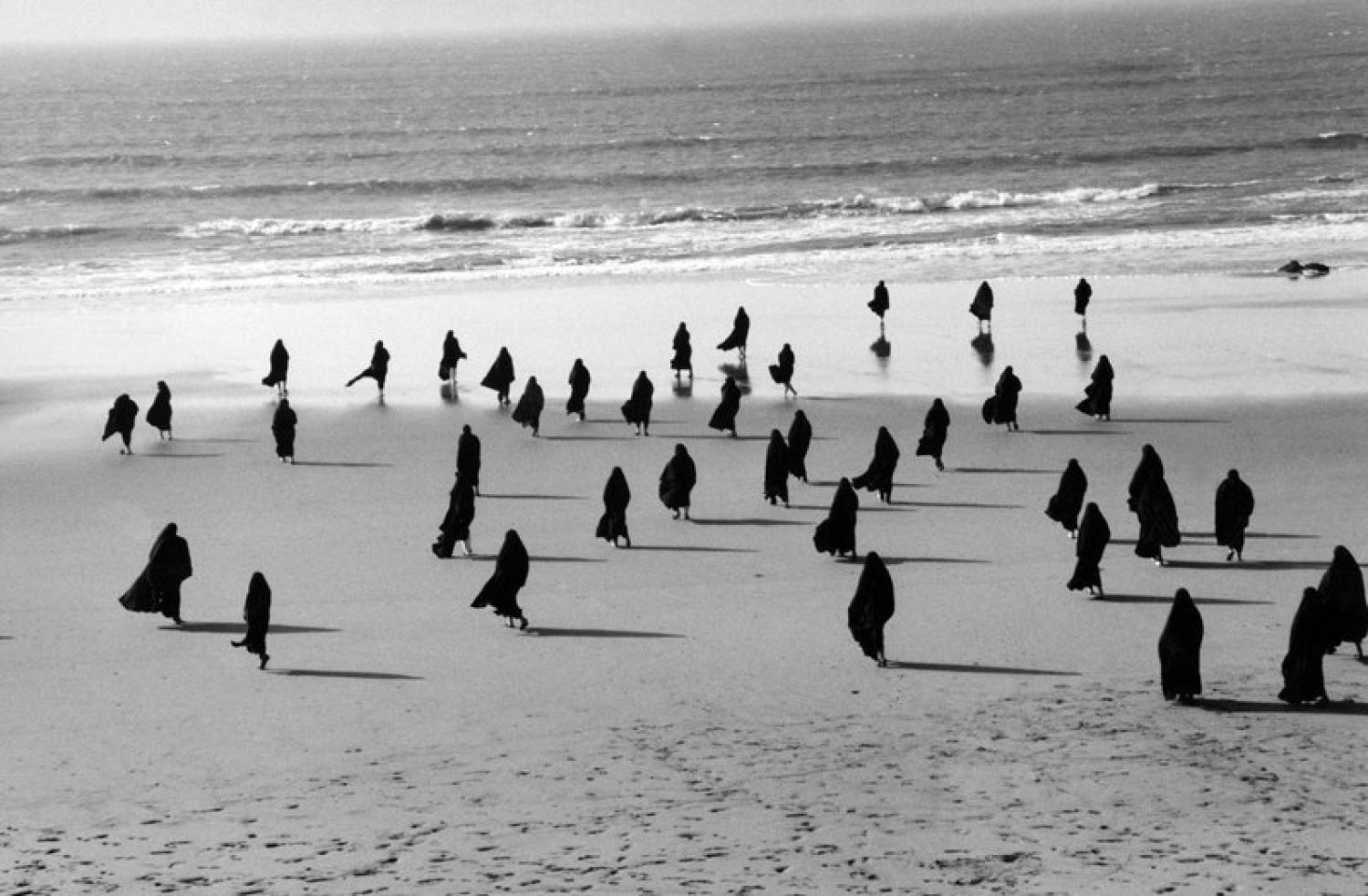 Figures walking on a beach