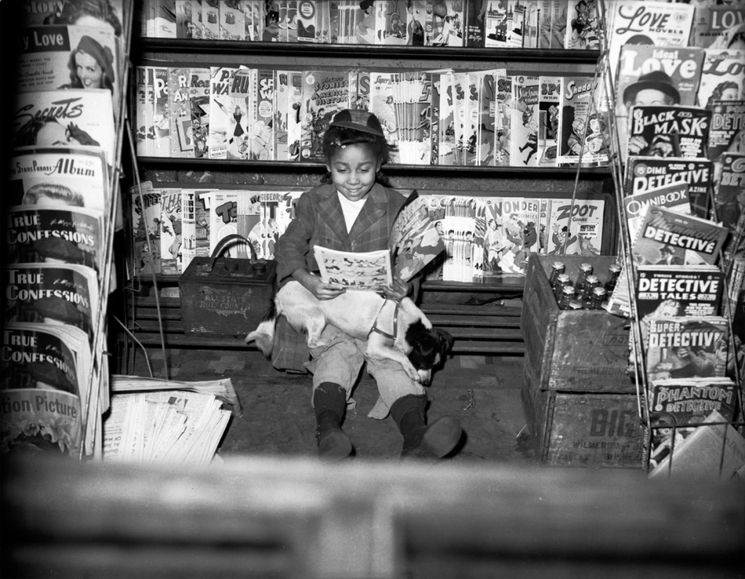 A young girl reading a magazine outside