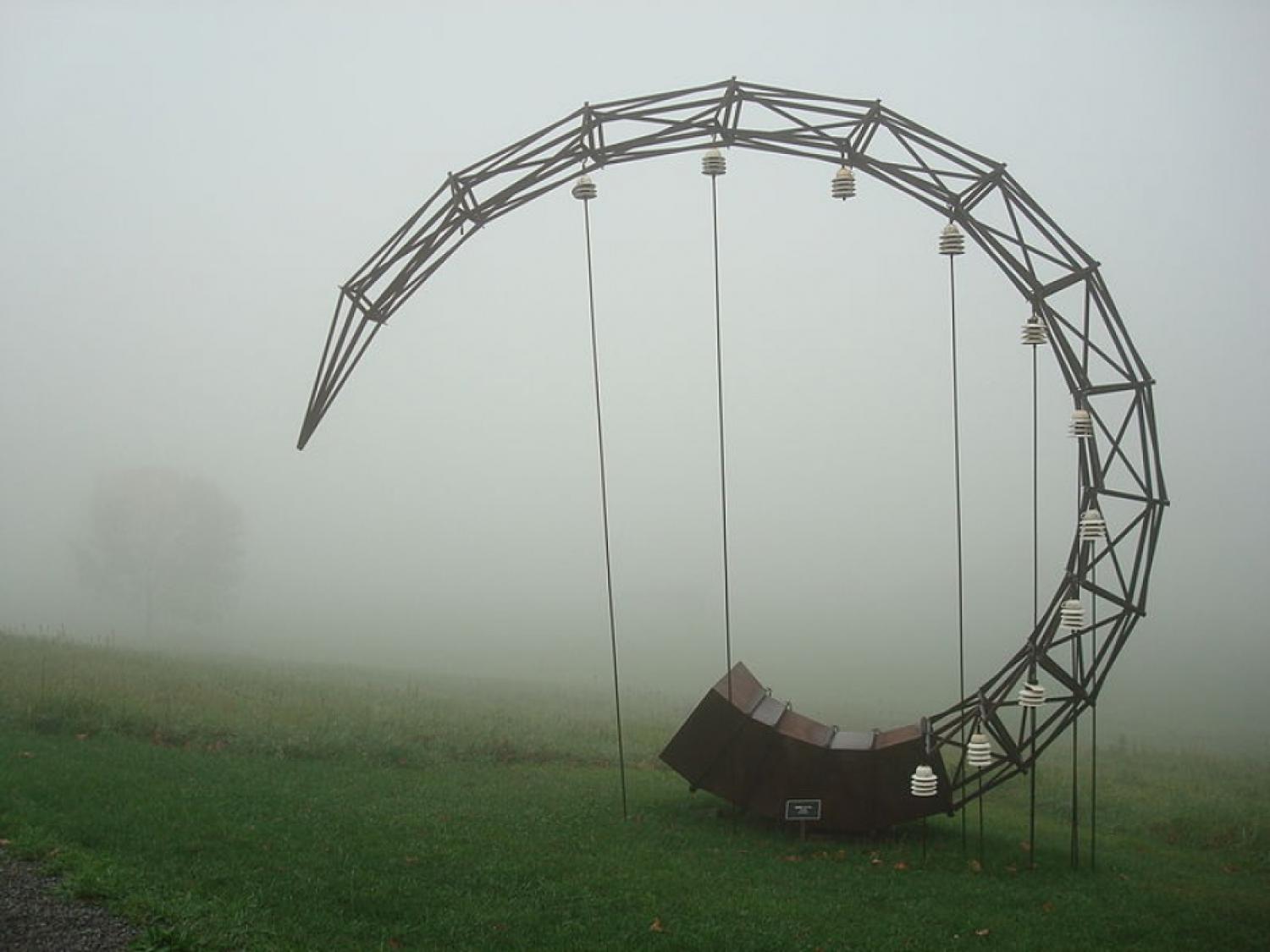 A horn-shaped wooden structure in a field