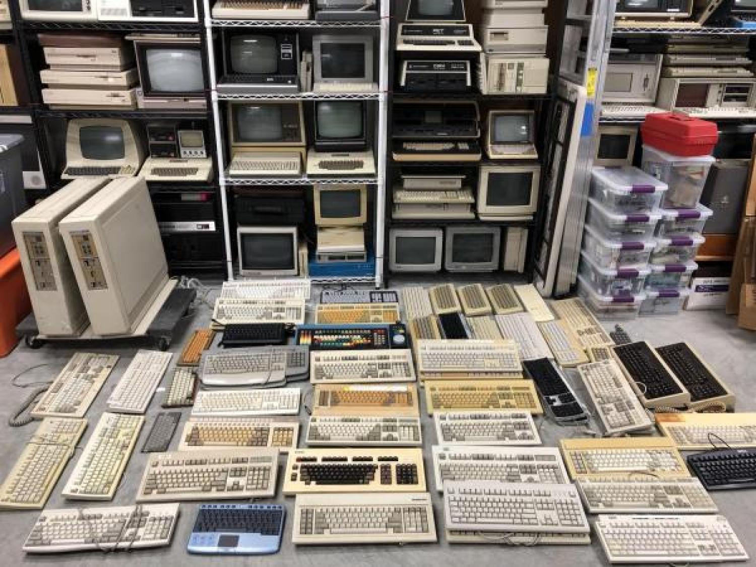 Stacks of computers and keyboards on shelves
