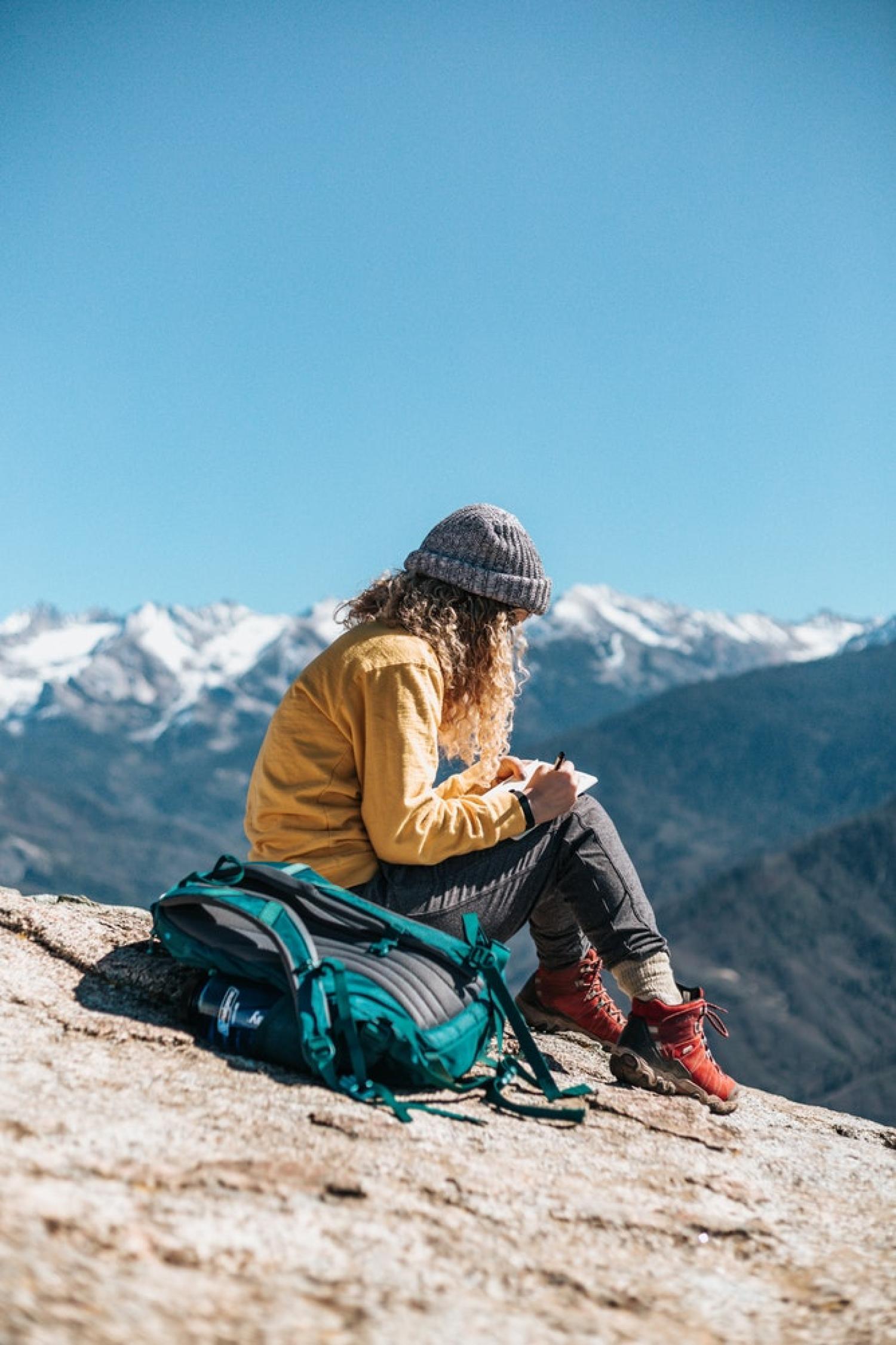 Woman writing on a mountaintop