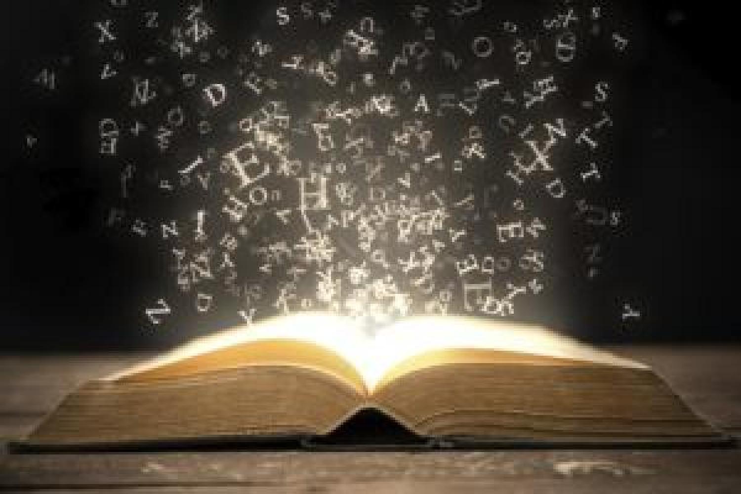 Letters floating out of an open, illuminated book on a table