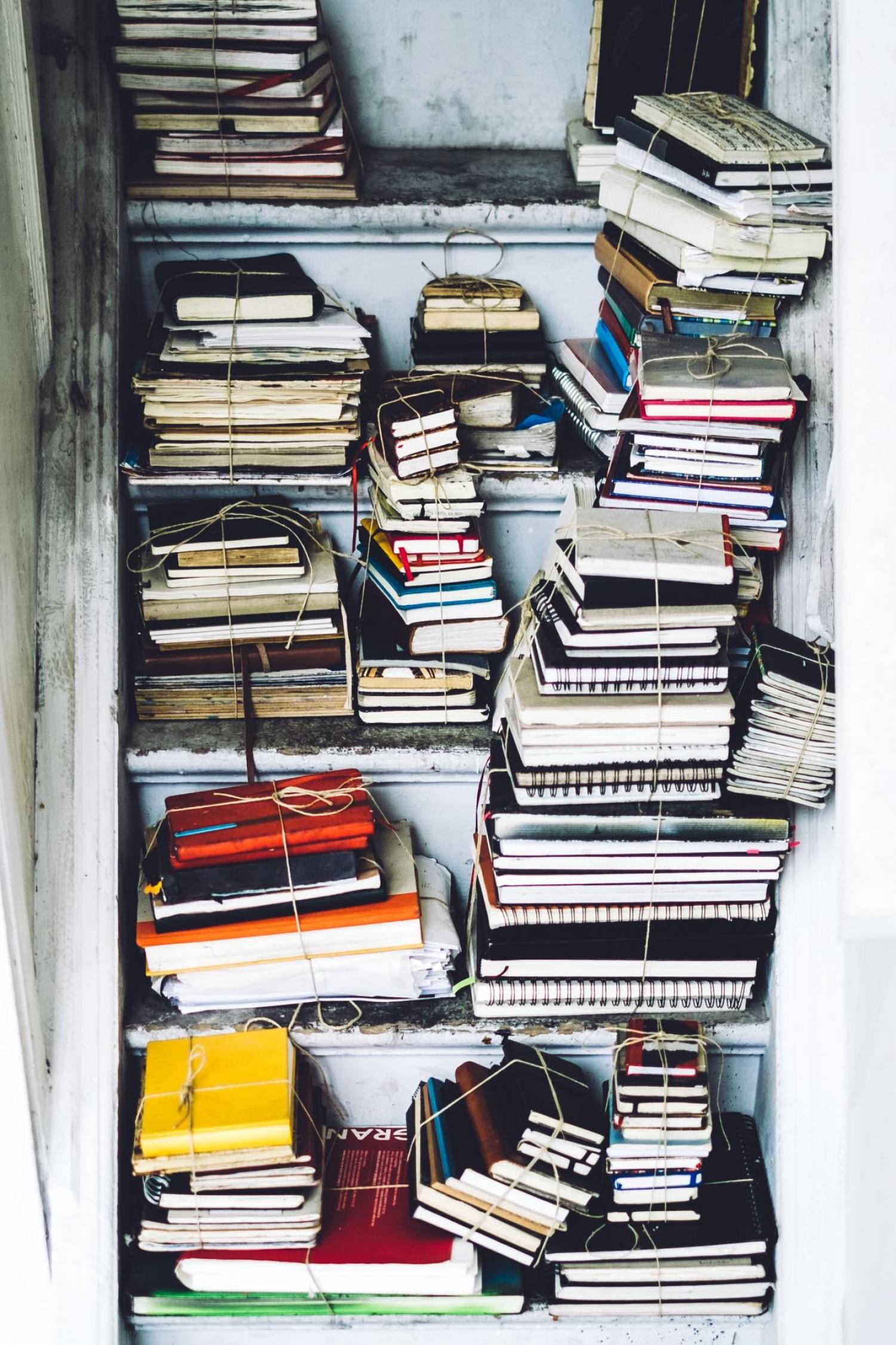 a bunch of books stacked in a stairwell