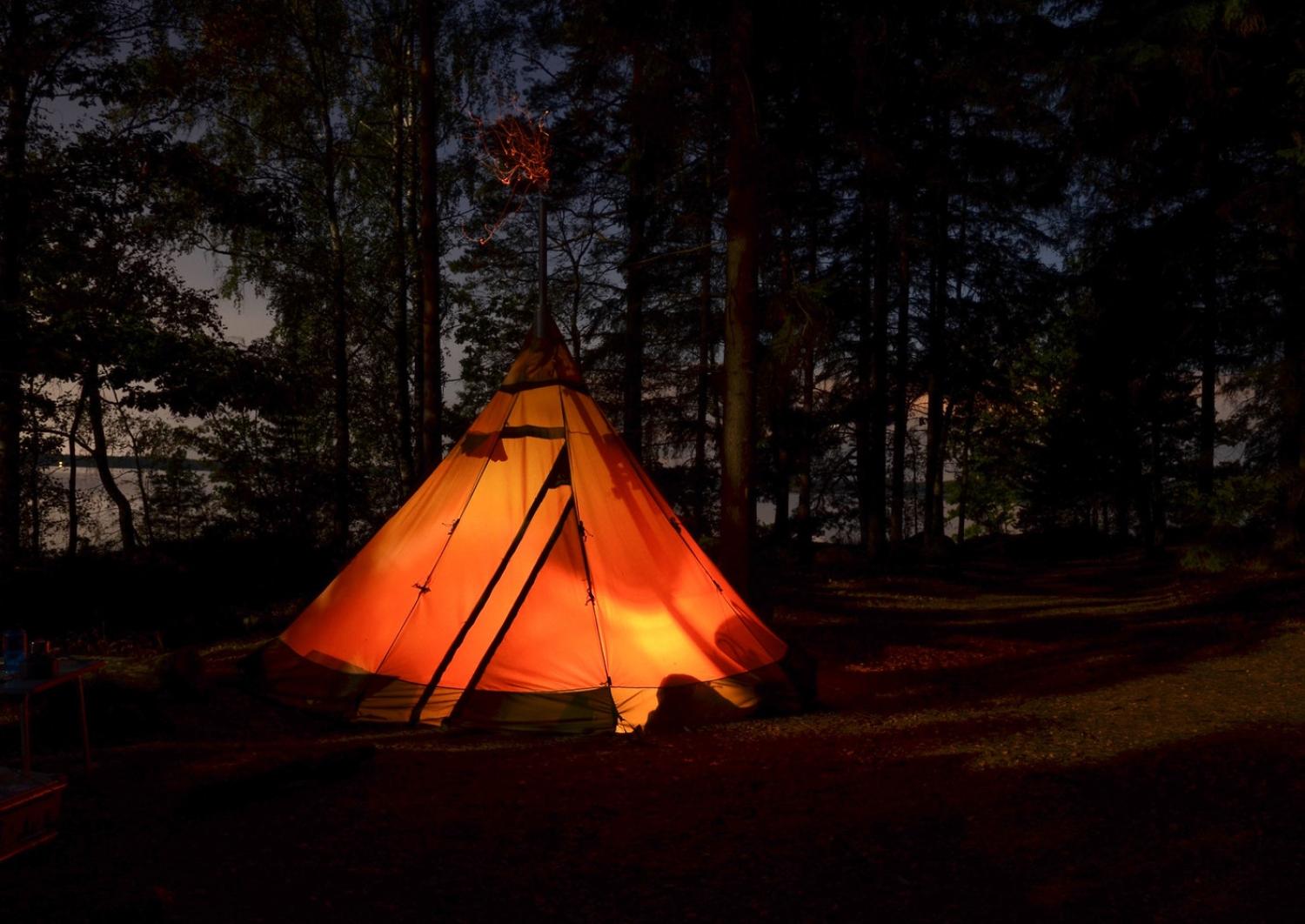 A tent lit up from the inside at night