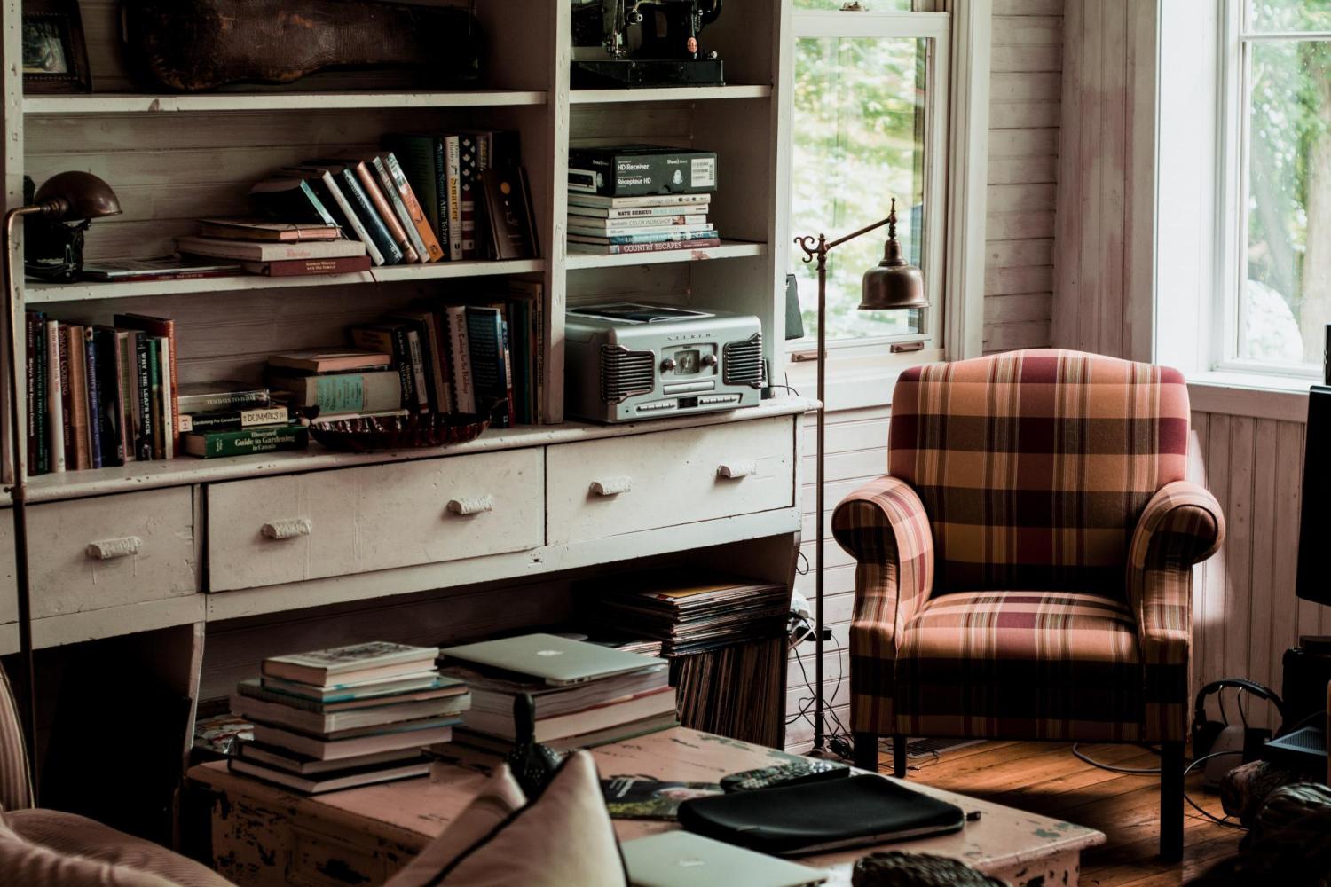 books on a table beside an armchair
