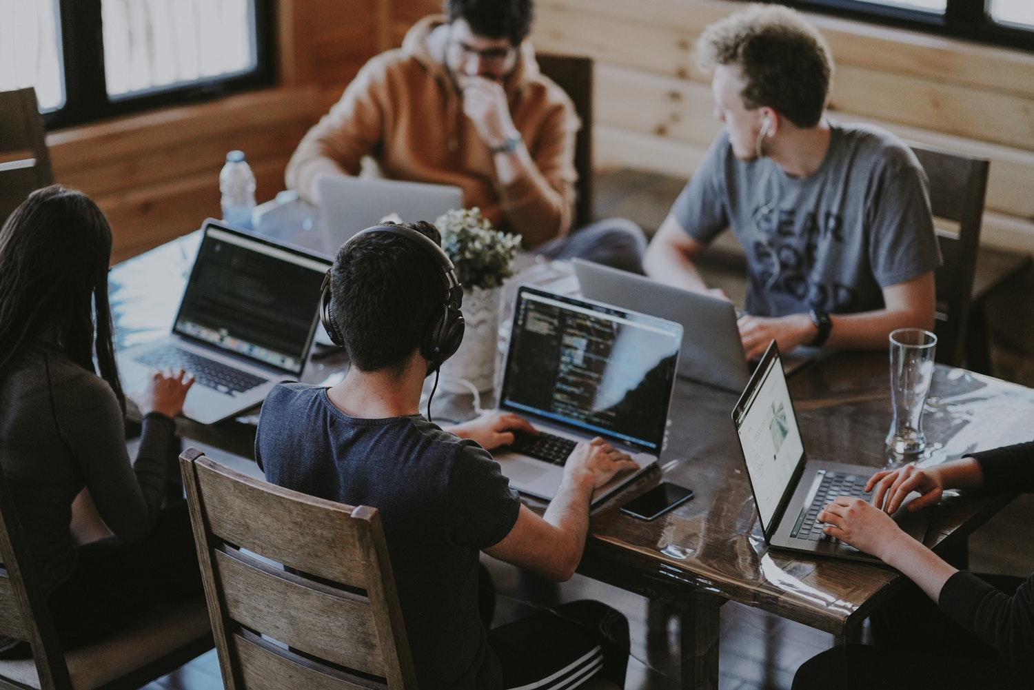 People sitting at a desk working at computers