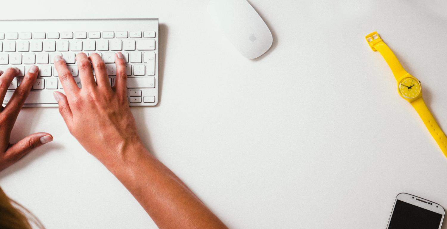person on computer with yellow watch