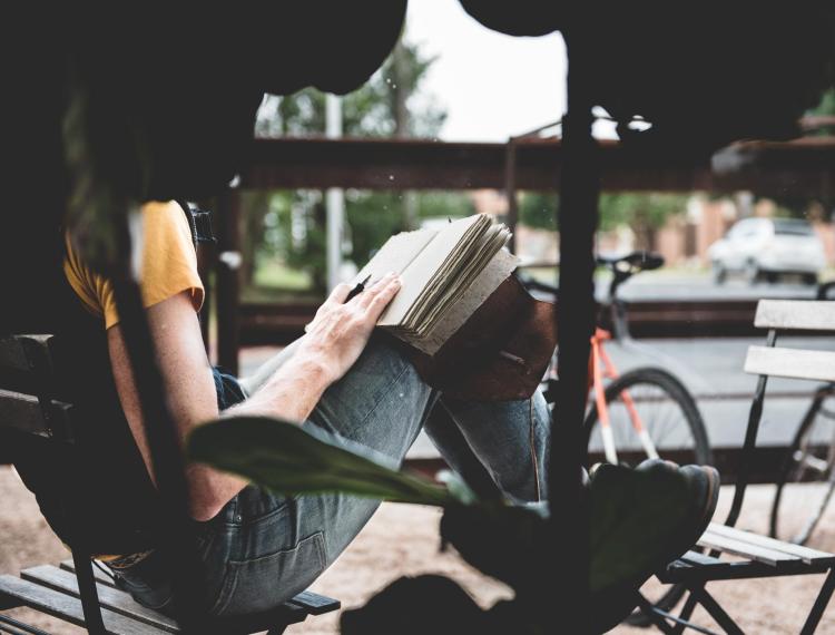 Woman on a park bench with a notebook