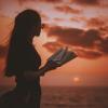 WOMAN READING AT SUNSET