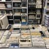 Stacks of computers and keyboards on shelves