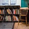 A wooden chair next to a bookshelf