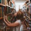 Woman picking a book from a bookshelf