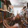 Woman picking a book from a bookshelf