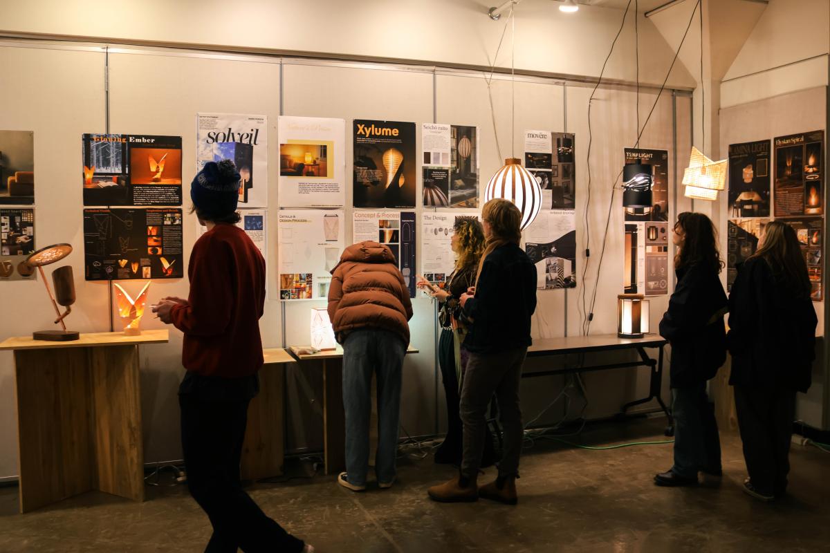 Students look at student work pinned to the walls at Open House