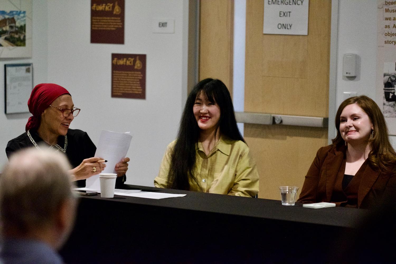 Azza Kamal sits with two panelists at a table