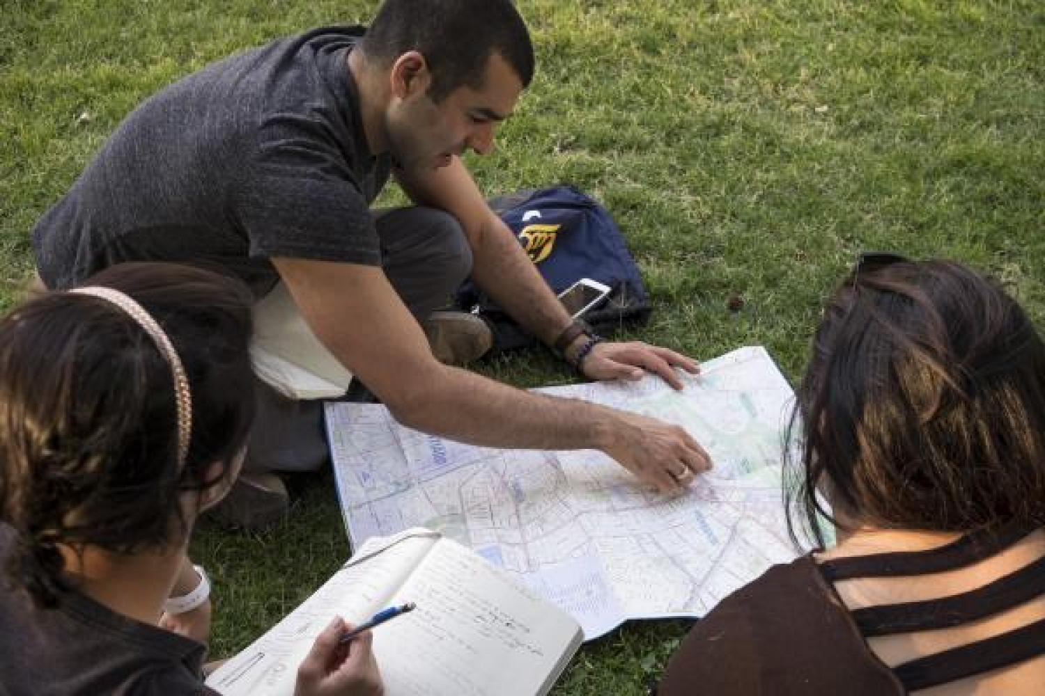 Assistant Professor, Alicia Gonzales and Kristina Lu view a map of Santiago