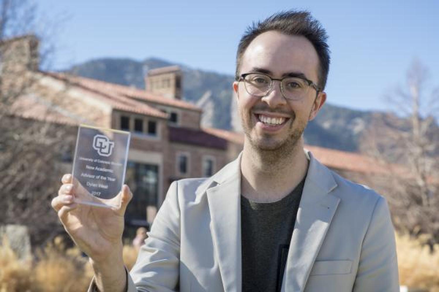 Dylan West holding his award for Outstanding New Advisor