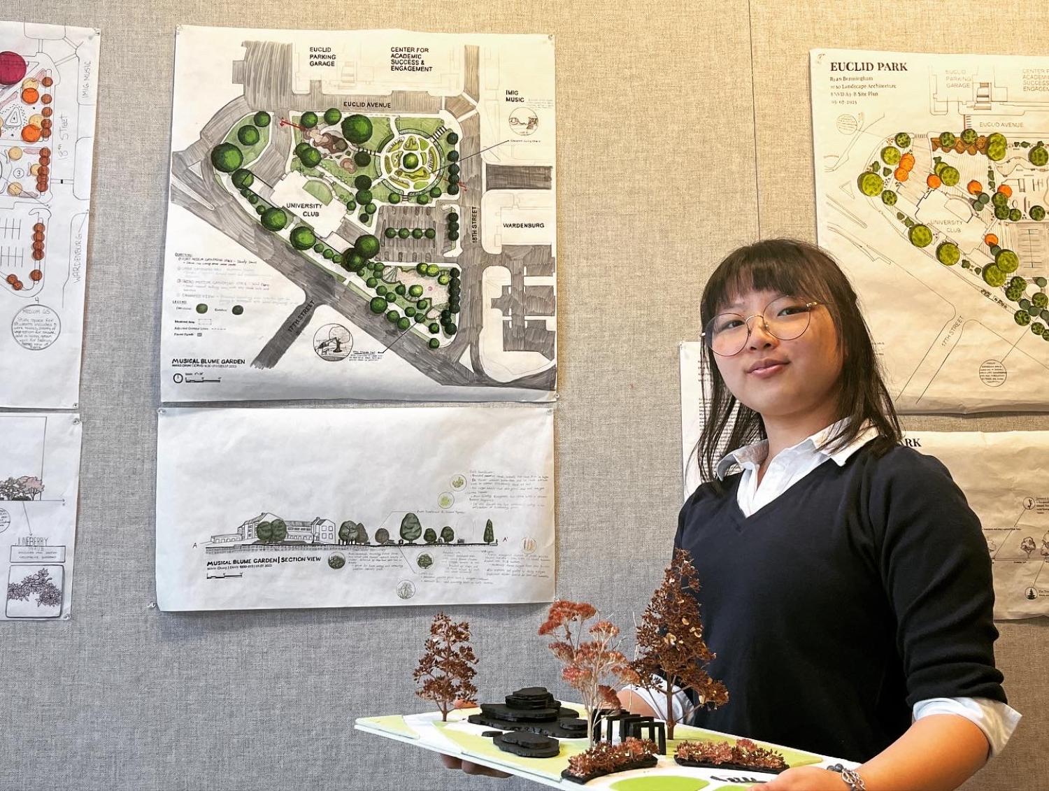 Nicole Chung stands in front of a pin-up of her work