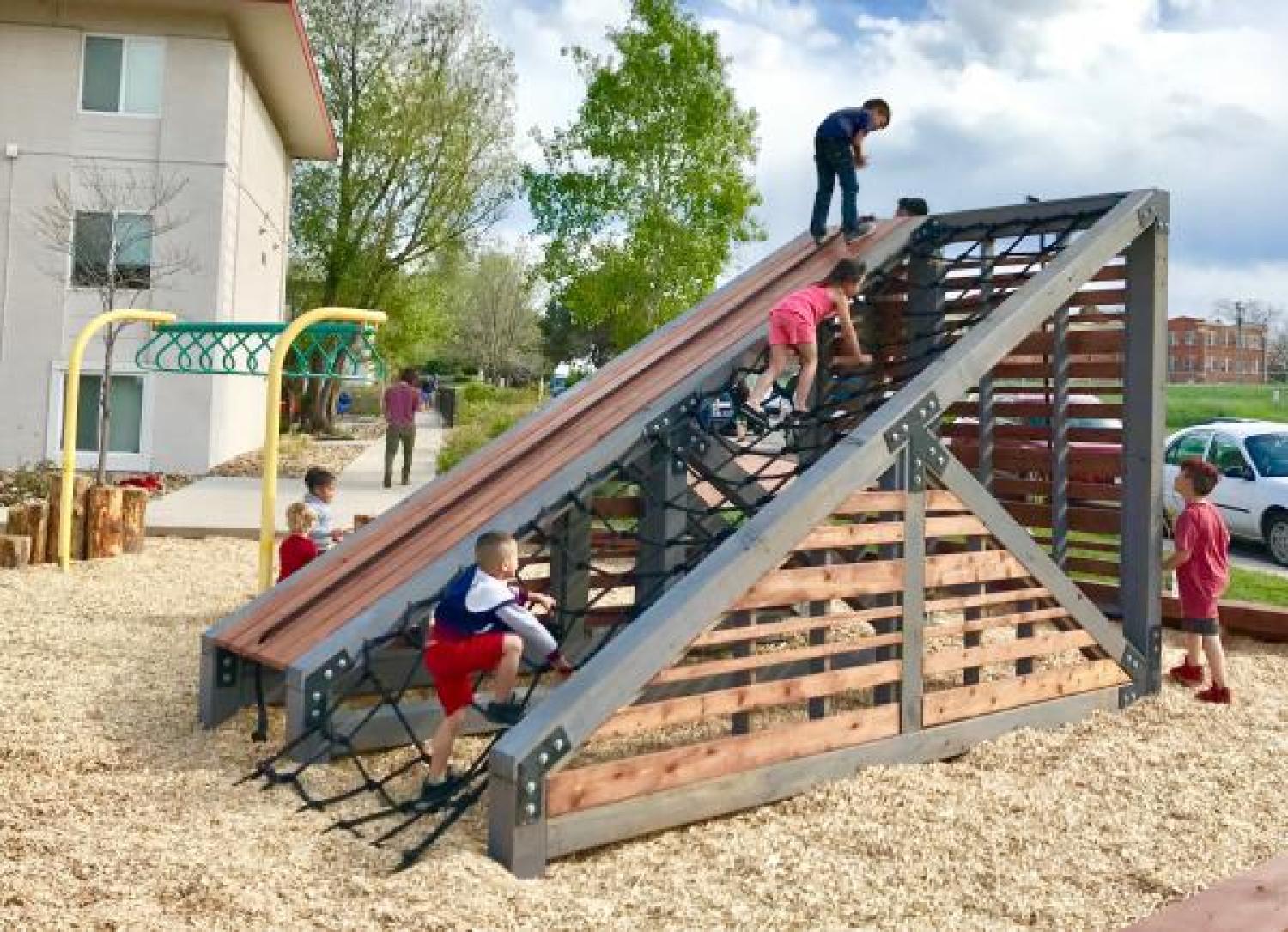 Children playing on a playground built by 18 student in the Program of Environmental Design in Lakewood, Colorado.