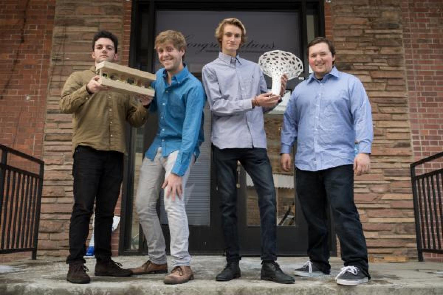 Winners of the Laka "Architecture that Reacts" design competition holding their winning designs on the steps of the ENVD building.