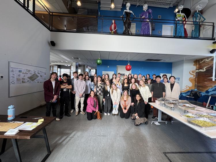 Students stand facing the camera at the lower floor of a youth center.