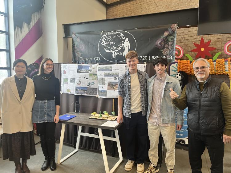 Students stand in front of their posters at the youth center