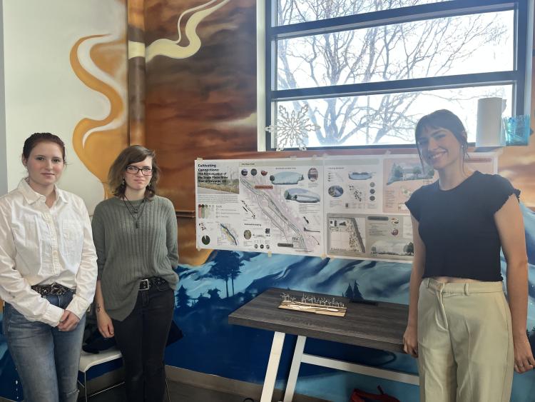 Students stand in front of their posters at the youth center