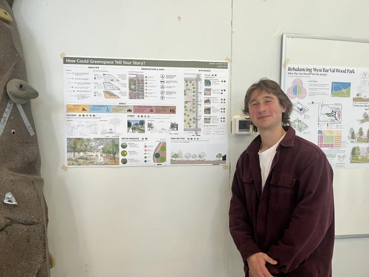 A students stand in front of their poster at the youth center