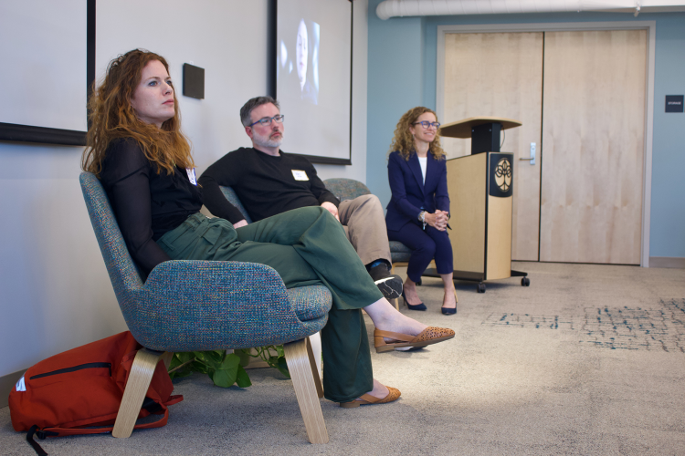 The three panelist listen to an audience member asking a question