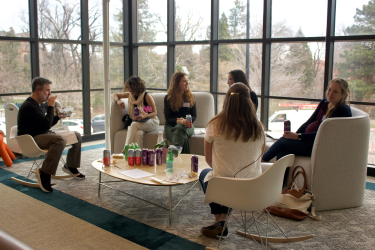 A small group of attendees sit in a circle eating lunch