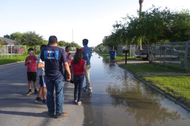 Colonias residents in Brownsville, Texas examine a flooded road in the neighborhood.
