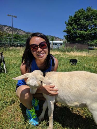 Elyse posing next to a baby goat.
