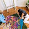 Sophie and her collaborator work on a tufted textile map