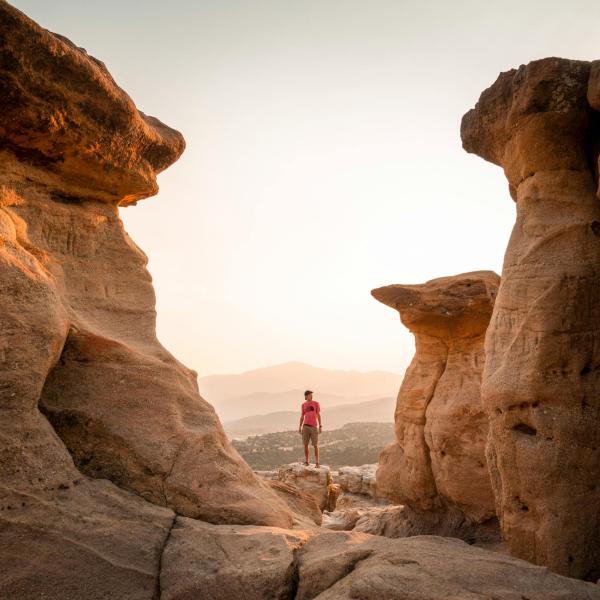 Person standing in canyon with rocks around them.
