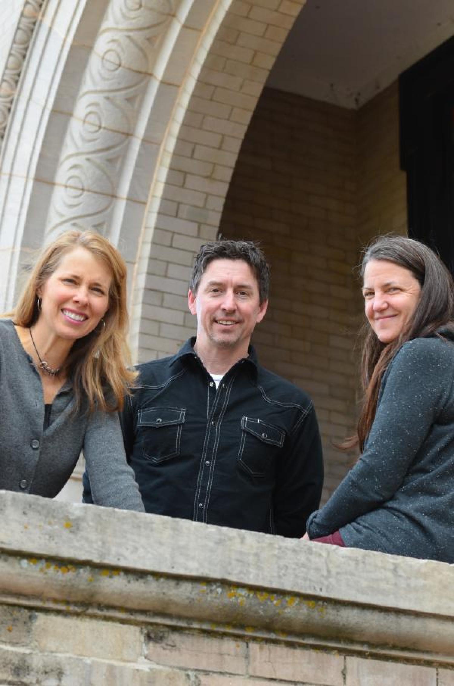 Professors stand together on patio