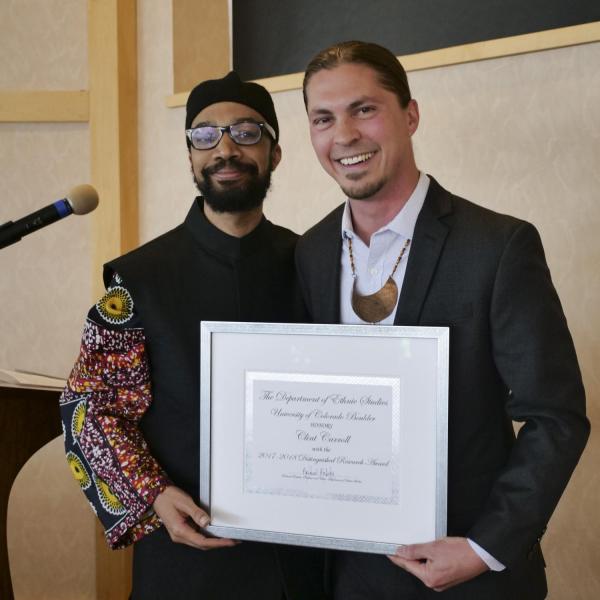 Dr. Clint Carroll receiving the Chair's Distinguished Research Award from Dr. Reiland Rabaka