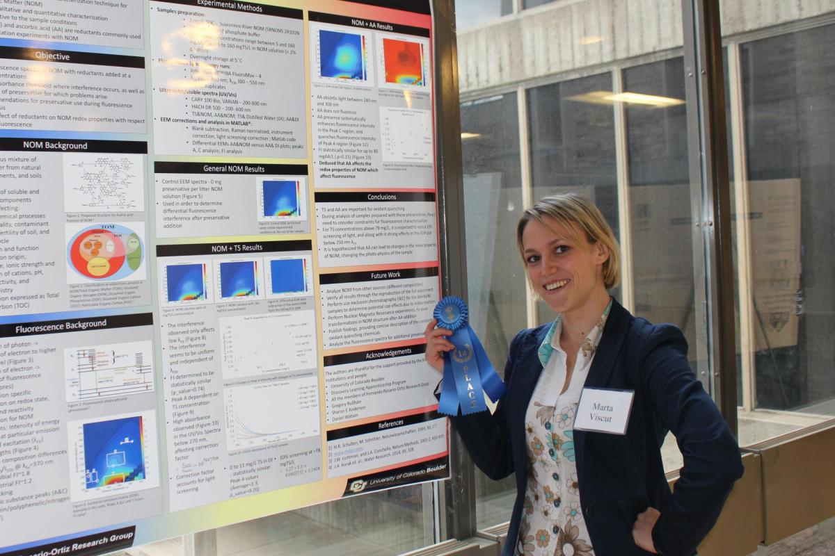 Marta Viscut with a blue ribbon and a research poster.