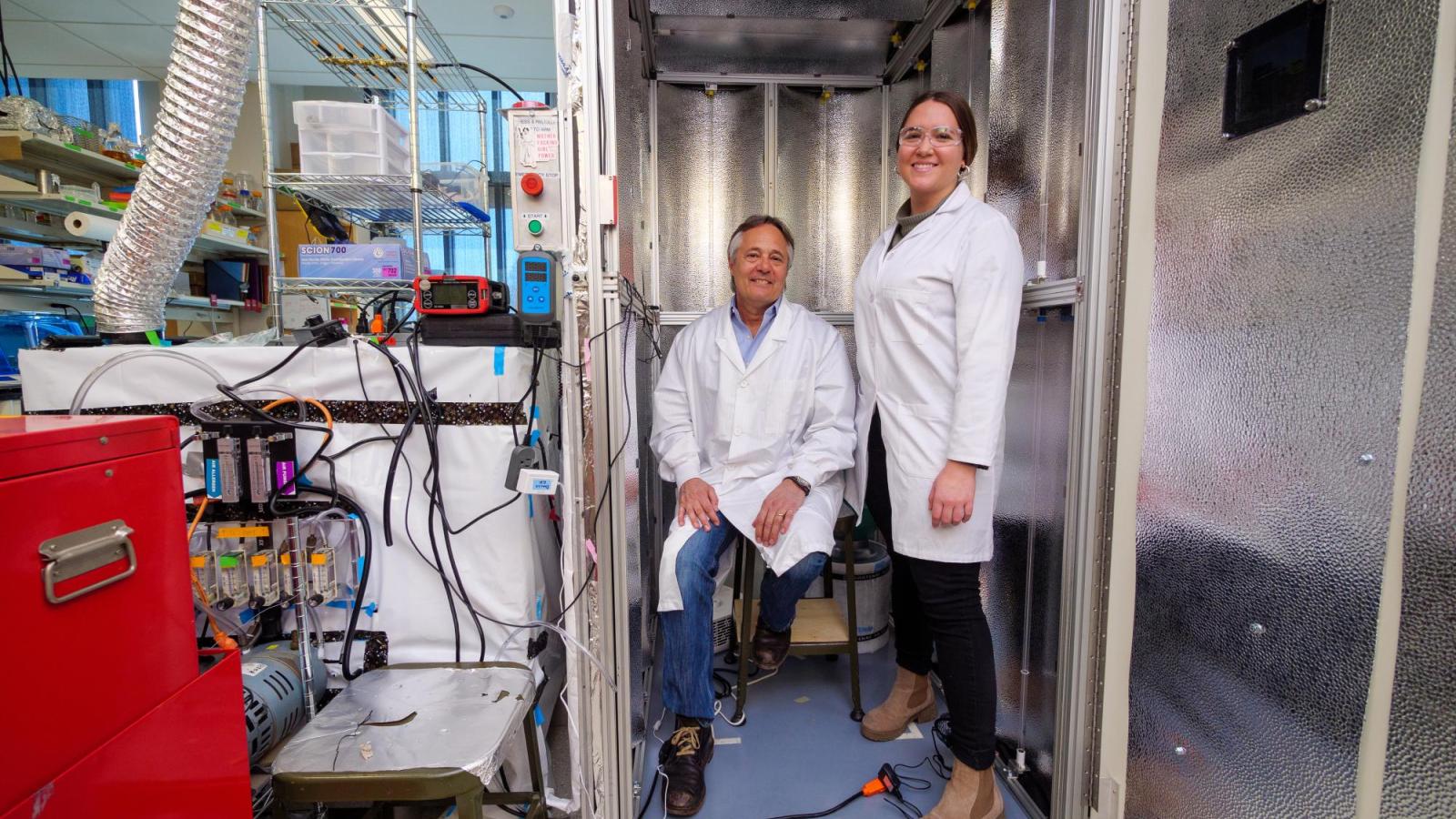 Professor Mark Hernandez and doctoral graduate Marina Nieto-Caballero stand inside a bioaerosol chamber in the Environmental Engineering disinfection laboratory.