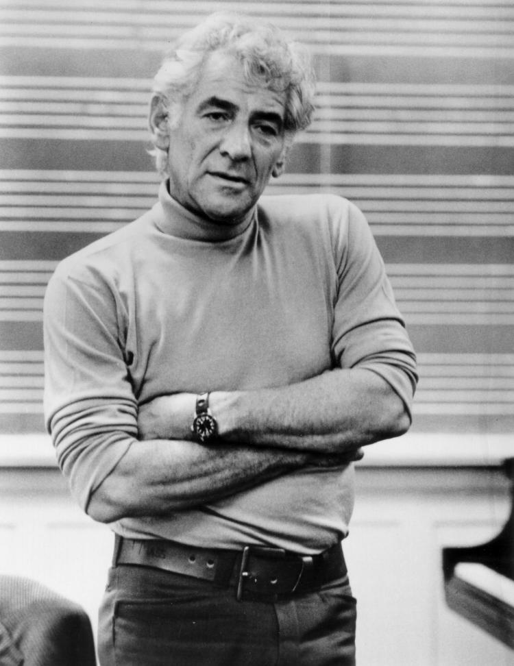 Leonard Bernstein standing with arms folded