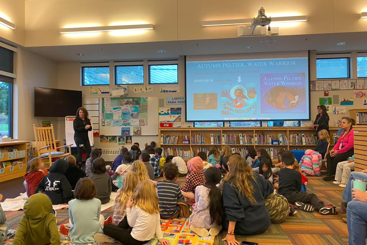 Author presenting to students in library