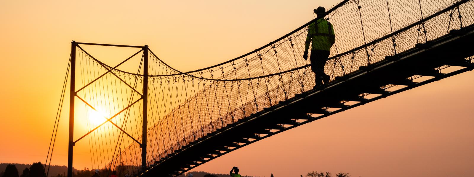 Person walking across a suspension bridge