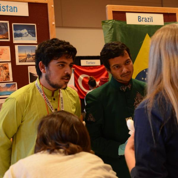 Two students from the Pakistan booth talking with some visitors at their booth.