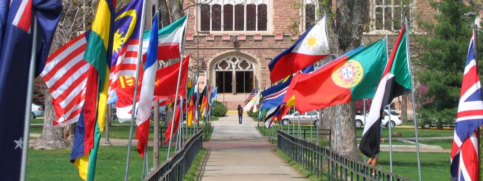 Flags representing various countries line the walkway to Macky Auditorium on the CU Boulder campus