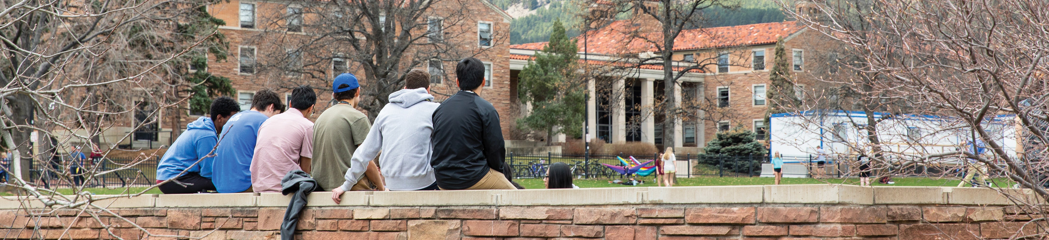 students sitting on a bench looking at mountains