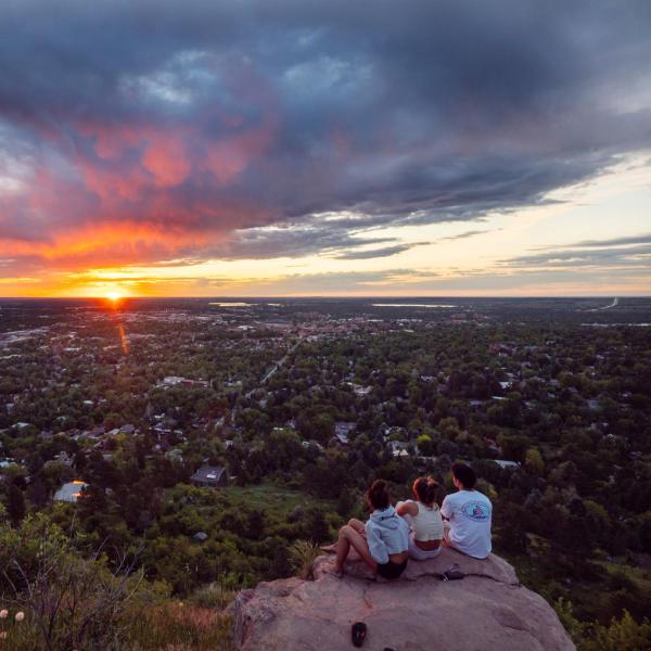 three friends watch the sunrise at Flagstaff