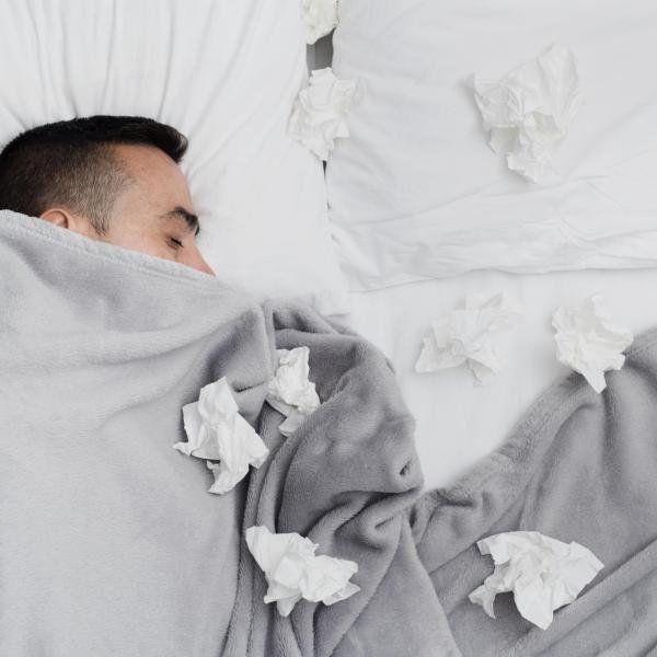 A person laying in bed next to tissures